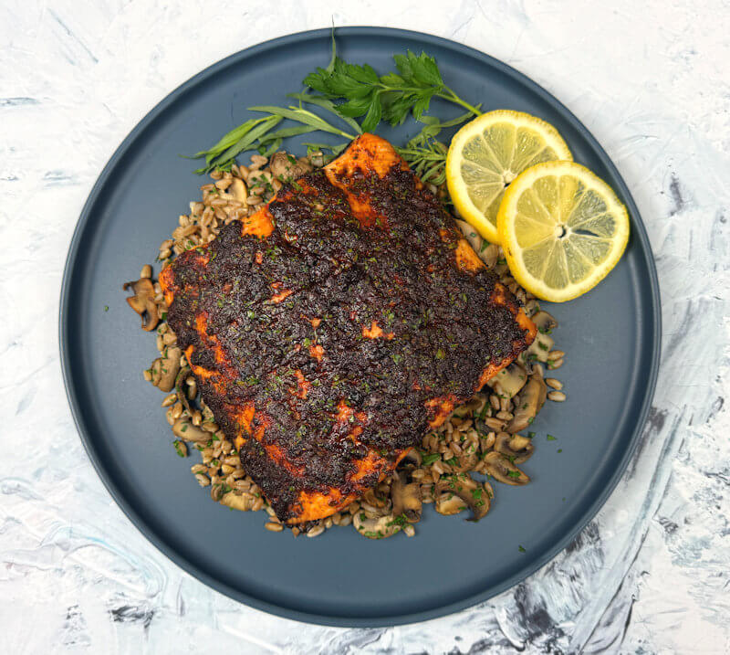Herb crusted salmon on a bed of farro with mushrooms.