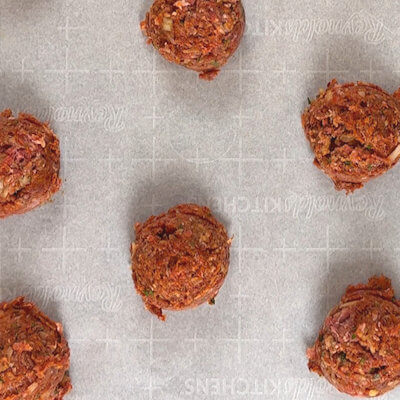 Step 2 - With an ice cream or cookie scoop or your hands form equally sized meatballs. Any size is a good size, but keep in mind that the bigger the meatball, the longer it takes to cook the through. Place the meatballs on a baking sheet lined with parchment paper.