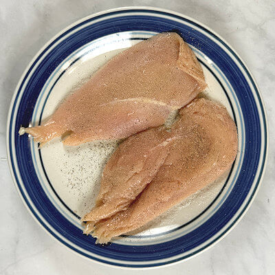 Step 3 - Cut a chicken breast in half, horizontally and pound on them to reach an even thickness. Season the cutlets on both sides with salt & pepper.