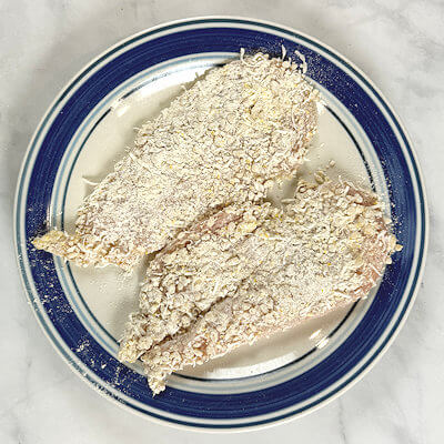 Step 4 - Dip the chicken cutlets in the egg white-milk mixture and then and dip it into the nut-flour mixture to coat on all sides. Tap off the excess.