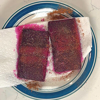 Step 2 - Transfer the salmon fillets onto paper kitchen towels and dab them dry. Season with salt, pepper, cumin and coriander.