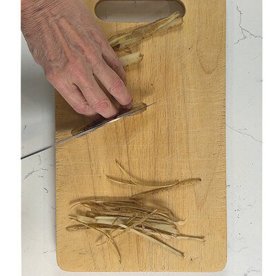 Step 4 - While the fish cooks, cut potato skins in very thin strips. Heat oil in a skillet and fry these potato skin strips until they are crunchy.