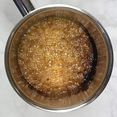 Step 2 - Remove the pan from the heat and add cream, butter, Granulated and brown sugar and stir.Bring back to a boil until the temperature reaches 252°F.