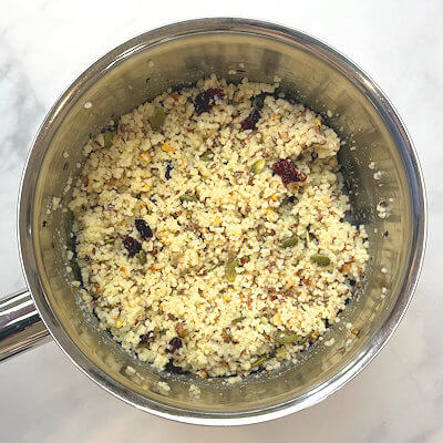 Step 3 - Transfer all ingredients (chopped nuts, cranberries, flaxseed, pepitas and salt) to the couscous and mix.