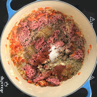 Step 4 - While breaking up the ground beef, add the spices; cayenne pepper, smoked paprika, oregano, onion powder, garlic powder, cumin, salt & pepper. Mix with the ground beef and cook until the ground beef is browned.