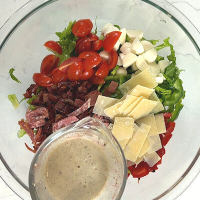 Step 5 - Pour the dressing over the salad and mix. The creamy dressing will cling to every chopped edge and nook, coating the greens and wrapping around the meats and cheeses so nothing feels separate.