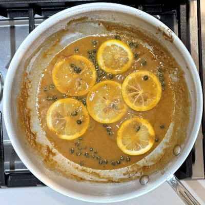 Step 4 - Add the lemon juice, the capers and lemon slices. Stir and allow to warm in the sauce.