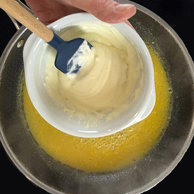 Step 4 - Mix the cornstarch and the crème fraîche and add this to the orange mustard in the skillet. Combine and allow the sauce to thicken a little. Bring it to a low simmer to fully activate the thickening properties of the cornstarch.