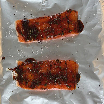 Step 2 - Place the fillets on a grill tray, covered with aluminum foil. Season the salmon with salt & pepper and brush them with the maple syrup mixture. Cook the fish at 400°F for about 25 minutes. The fish should reach an internal temperature of max. 145°F.If you like to cook the fish directly on the grill, that perfectly fine, but the cooking time may be shorter.