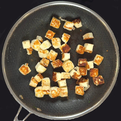 Step 2 - Cut halloumi in 1/2-inch pieces and pat dry. Heat some olive oil in a skillet and cook the halloumi until golden-brown on all sides. Remove from skillet.