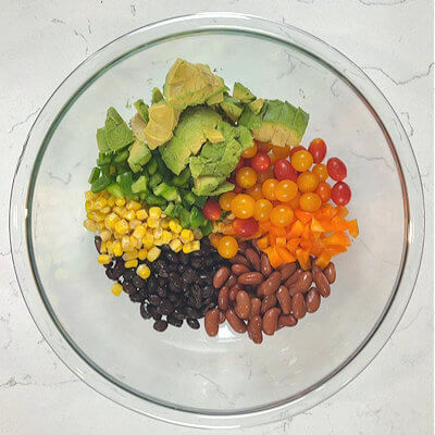 Step 3 - Combine the ingredients. Transfer the black beans, red kidney beans, green and orange bell pepper, tomatoes, avocado and sweet corn into a large mixing bow. Mix gently.