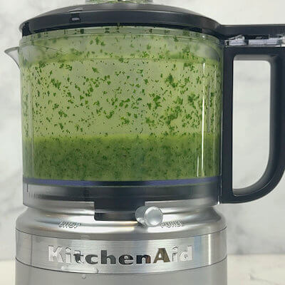 Step 3 - Place the basil leaves in a food processor, pour in the oil and blend together.