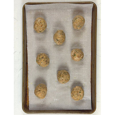 Step 2 - Divide the mixture into 8 equal portions and place each meatball on a baking sheet lined with parchment paper.