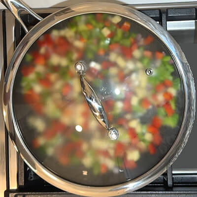 Step 2 - Cover skillet and cook over medium low heat until onions and bell peppers are softened and potatoes are starting to brown. Stir frequently.