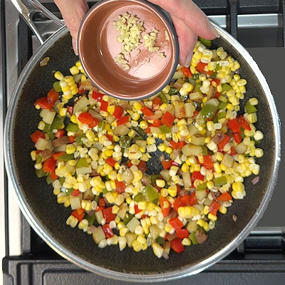 Step 3 - Add corn and garlic, again stir frequently and sauté until the corn is tender, but still with some bite left.