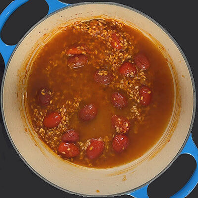 Step 6 - Add the warm broth, in small increments, and stir until fully absorbed. Continue adding broth only after the previous amount is absorbed and add the red pepper flakes as well. Keep the rice at a medium simmer for the entire cooking process and stir regularly.