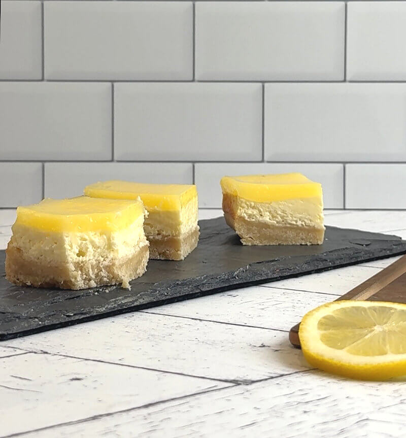 Lemon cheesecake bars with corner cut off.